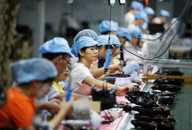 Employees work on the production line of a robot vacuum cleaner at a factory of Matsutek in Shenzhen