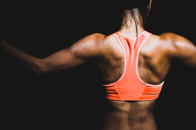 Rear View Of Female Athlete Against Black Background