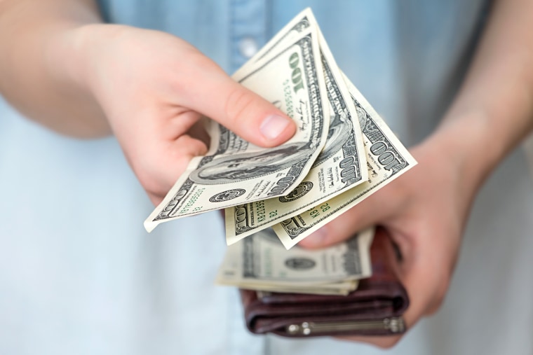 Midsection Of Woman Giving Currency From Wallet