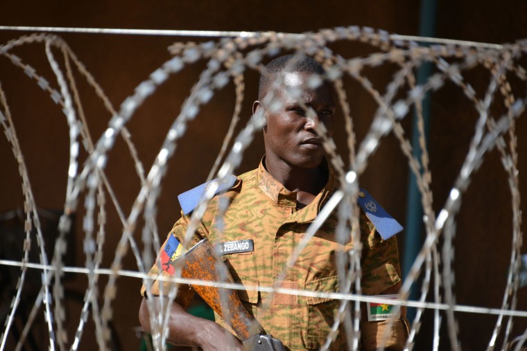 A Burkinabe man patrols the army's headquarters in Ouagadougou, Burkina Faso.