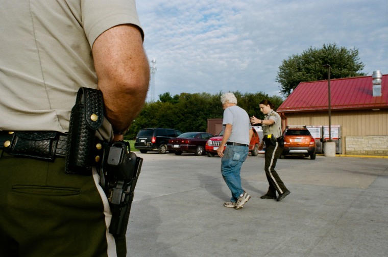 Officers at a scene where a man was spotted drinking in a parking lot in Anamosa, Iowa. 