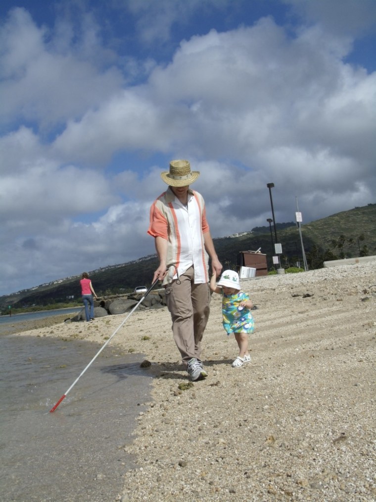 Tim and Abby walking on the beach together in Hawaii.