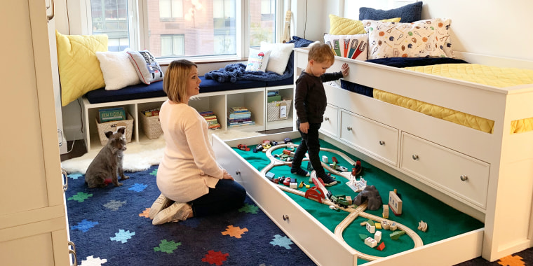 Calvin's new big-boy bedroom is filled with all of his favorite toys including a wooden train set that slides out from a drawer under his bed.