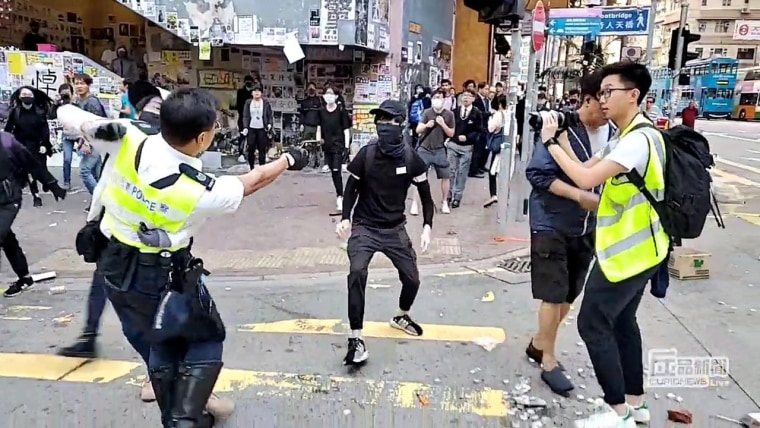 Image: A still image from a social media video shows a police officer aiming his gun at a protester in Sai Wan Ho, Hong Kong