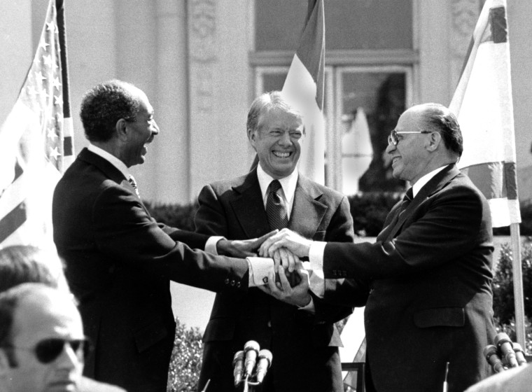 Egyptian President Anwar Sadat, left, U.S. President Jimmy Carter, center,  and Israeli Prime Minister Menachem Begin clasp hands on the north lawn of the White House after signing the peace treaty between Egypt and Israel on March 26, 1979. Sadat and Begin were awarded the Nobel Peace Prize for accomplishing peace negotiations in 1978. The rest of the Arab world shunned Sadat, condemning his initiative for peace. President Carter was pivotol for the two leaders to meet at Camp David and as a result, peace began between Arabs and Jews.