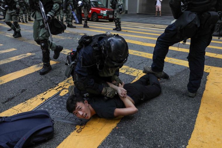 Image: Police detain a man during a flash mob to block roads in the Central district in Hong Kong