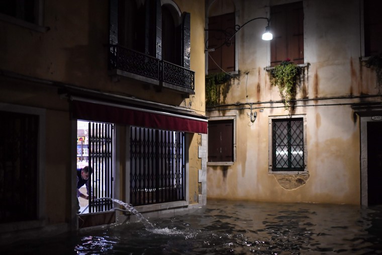 A shop owner pumps out water on Nov. 12, 2019 in Venice.