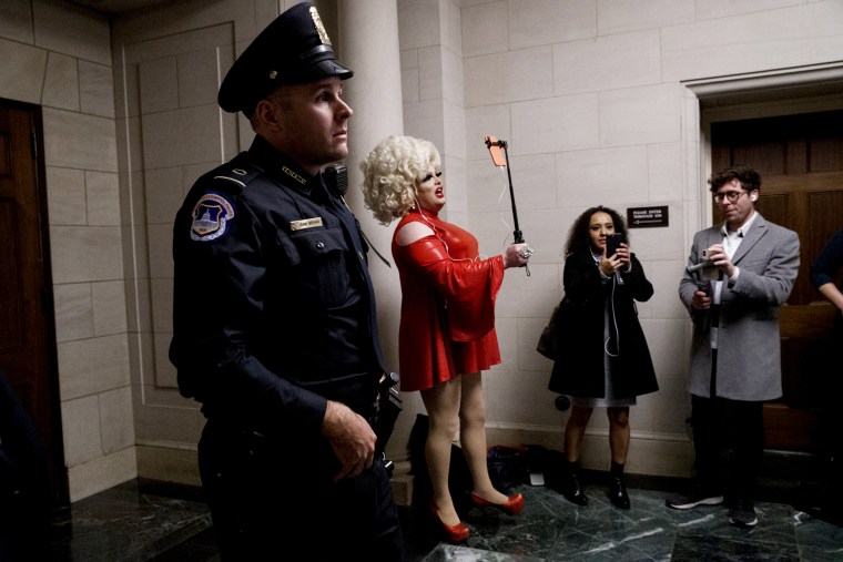 Image: Pissi Myles reports with her cell phone during the first public impeachment hearings on Capitol Hill on Nov. 13, 2019.