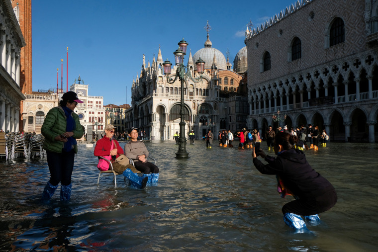 Image: Tourists take photos in the flood St. Mark's Square in Venice on Nov. 14, 2019.