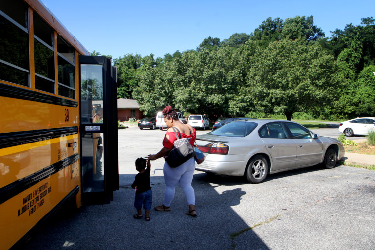 Image: Jasmine leads her son Josiah onto the bus that will take them to a Ready, Set, Enroll screening.