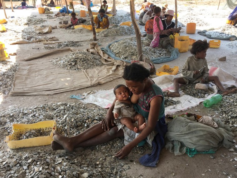 A mother breastfeeds one of her children in an open-air mica processing center in Amboasary-Sud.