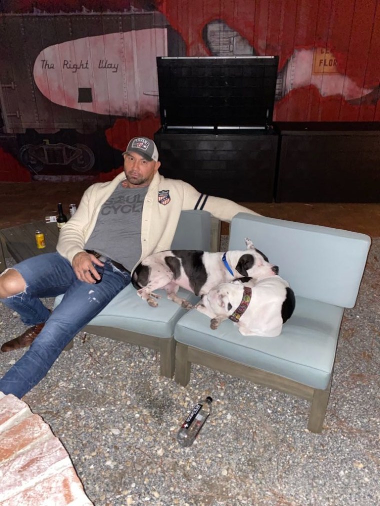 Dave Bautista sits with Maggie and Ollie after adopting them.