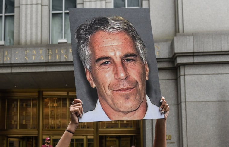 Image: A protester holds up a placard with a photo of Jeffrey Epstein in front of the federal courthouse