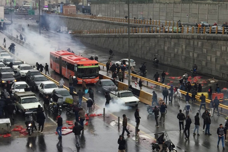 Image: People protest against increased gas price, on a highway in Tehran