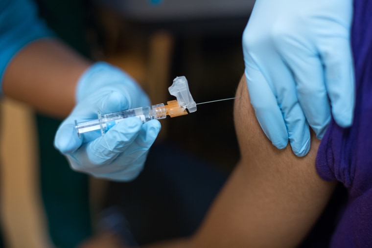 Image: Needle poking skin during administration of flu shot at Mary's Center, a community health center in Washington.