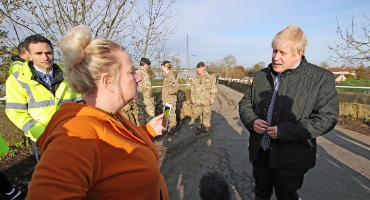 Image: Prime Minister Boris Johnson speaks with a local woman during a visit to Stainforth to see the recent flooding