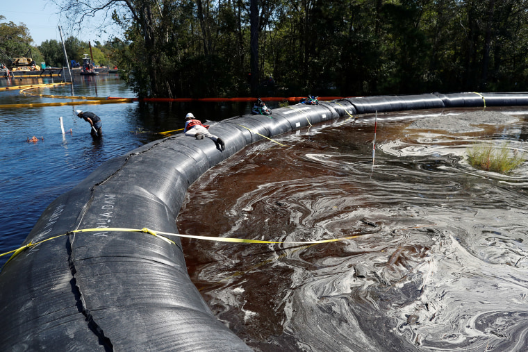 Santee Cooper workers check the water levels around a 6000 foot long Aqua Dam built to keep sediment from a coal ash retention pond from going into the flooded Waccamaw River in the aftermath of Hurricane Florence in Conway