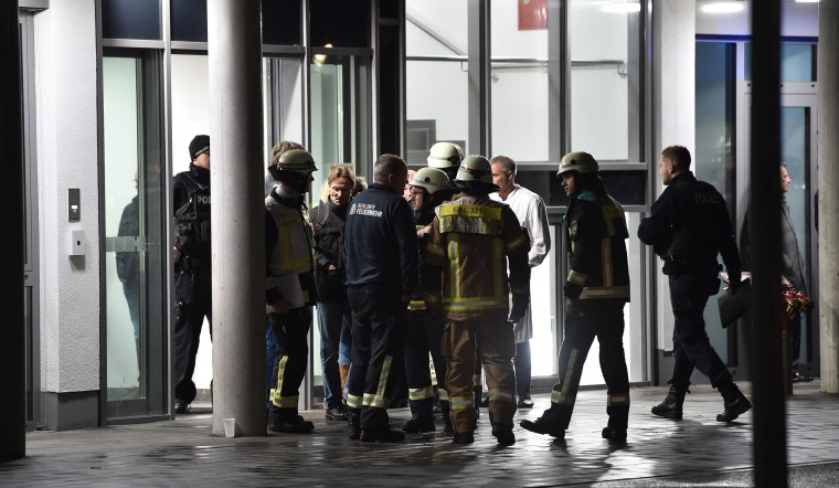 Image: Policemen, firefighters and medical staff stand in front of the hospital after a doctor was stabbed to death as he delivered a lecture at the Schlosspark hospital in the western Berlin neighborhood of Charlottenburg
