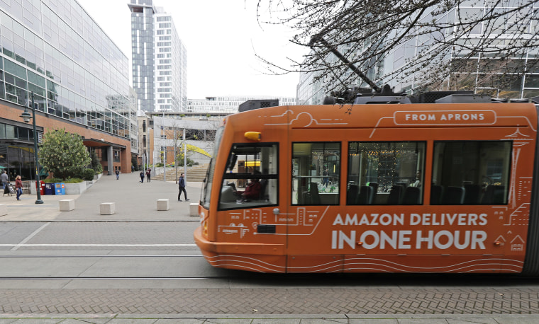 A South Lake Union streetcar with an advertisement for Amazon.com's same-day delivery service passes by an Amazon office building on Nov. 13, 2018, in Seattle.