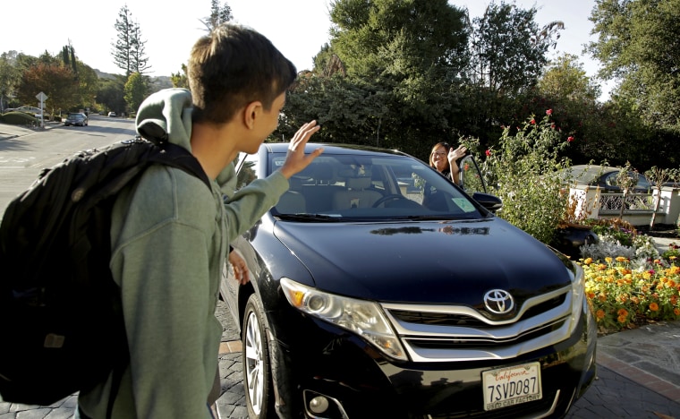 Image: SZum driver Stacey Patrick waves goodbye to student Saahas Kohli after dropping him off at home in Saratoga, Calif., on Oct. 29, 2019.