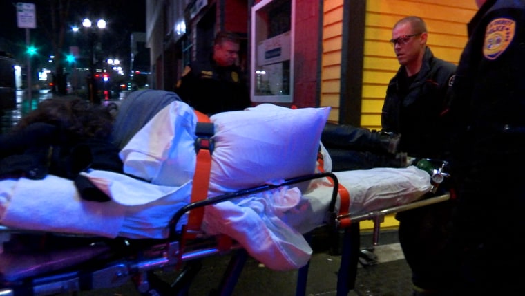 Image: Emergency workers remove a person who has overdosed from a bar in Everett, Wash.