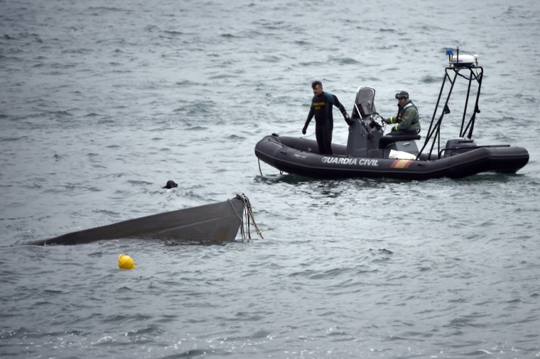 Image: The prow of a submarine used to transport drugs illegally emerges as Spanish Guardia Civil's divers work to refloat it in Aldan, northwestern Spai