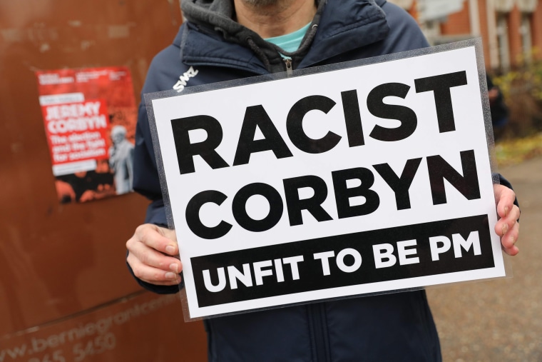 Image: An activist holds a placard outside the launch of Labour's Race and Faith Manifesto on Nov. 26.