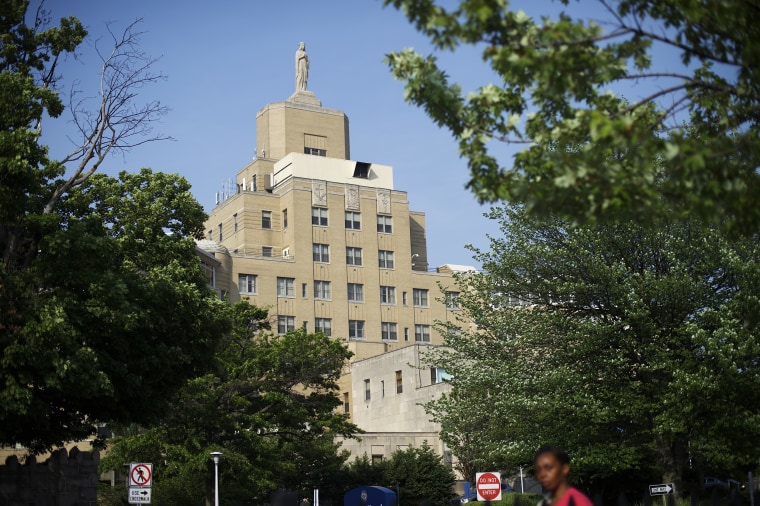 A pedestrian passes in front of Our Lady of Lourdes Medical Center in Camden, N.J.