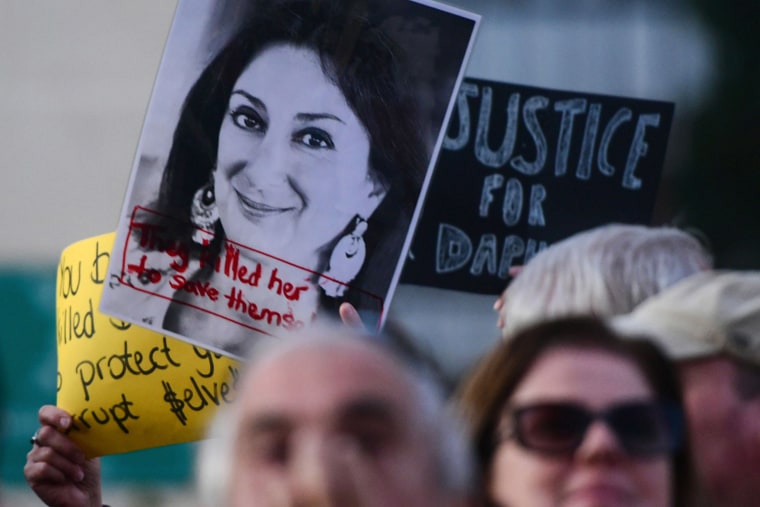 Image: Protesters holding a photo of killed reporter Daphne Caruana Galizia gather outside Parliament in Valletta, Malta,