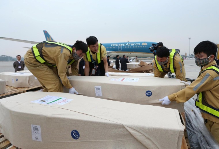 Image: Airport workers unload coffins, carrying some of the 39 bodies found on a truck container in Britain, from an airplane for homeland repatriation at Noi Bai airport in Hanoi