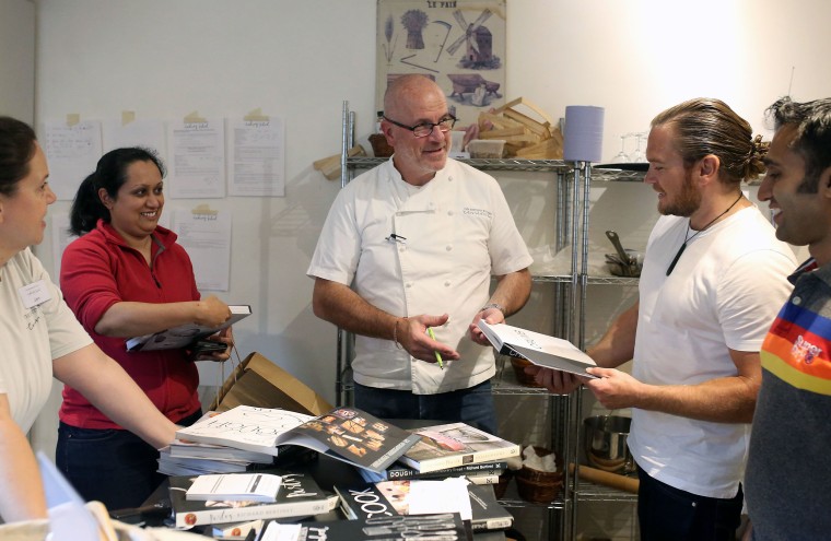 Image: French Chef Richard Bertinet signing copies of his cookery books for pupils at his cookery school in Bath, Somerset