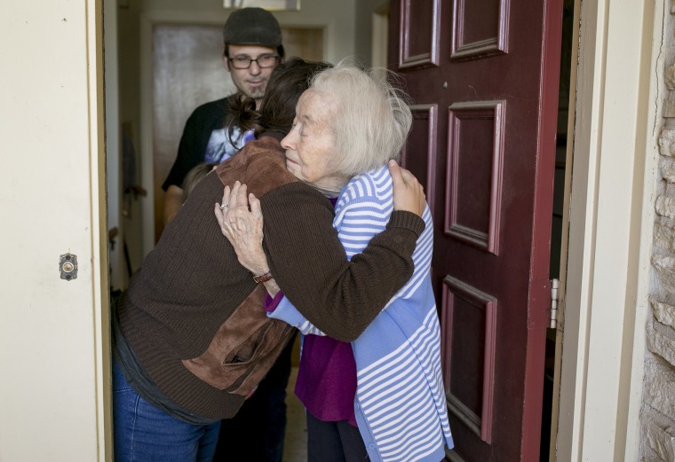 An elderly woman hugs a Meals on Wheels volunteer who delivered a Thanksgiving dinner in Austin, Texas.