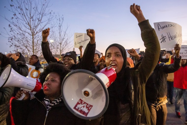 Demonstrators shout slogans during a protest at the Amazon fulfillment center in Shakopee, Minn