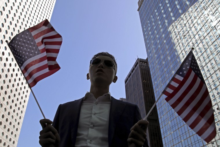 Image: A protester holds American flags during a demonstration in Central, the financial district of Hong Kong