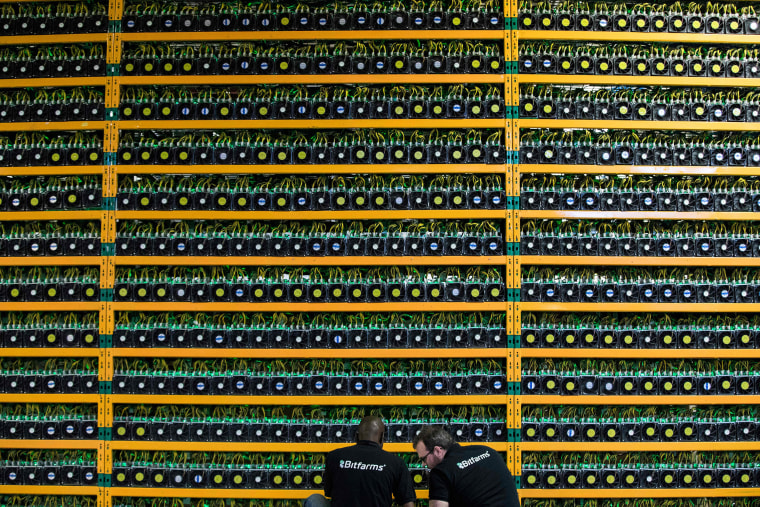 Image: Two technicians inspect bitcon mining at Bitfarms in Saint Hyacinthe, Quebec