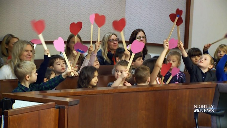 Michael's class waves hearts from their seats during the adoption proceedings.