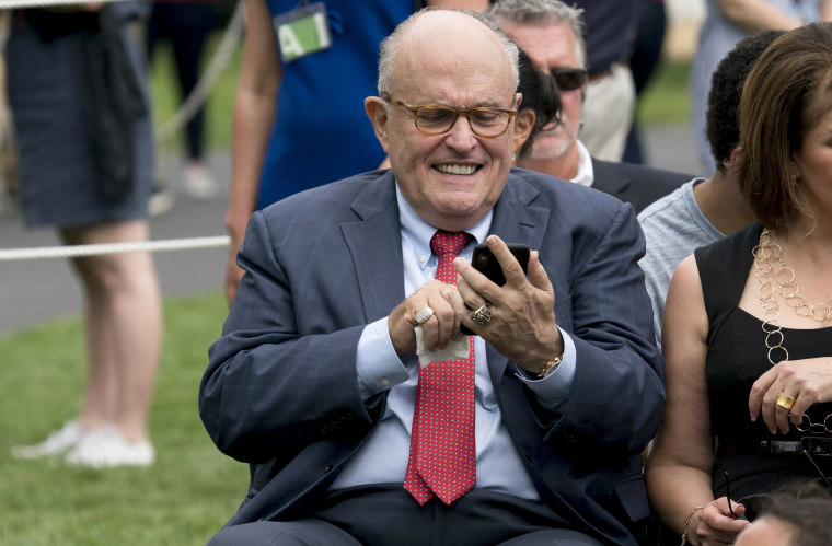 Rudy Giuliani checks his phone on South Lawn of the White House on May 29, 2018, in Washington.