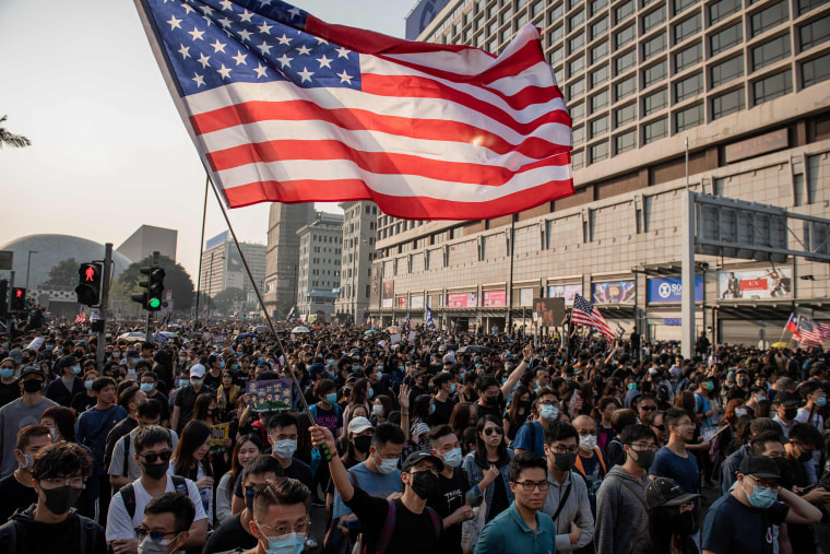 Image: Residents march in Hong Kong and wave an American flag on Sunday.