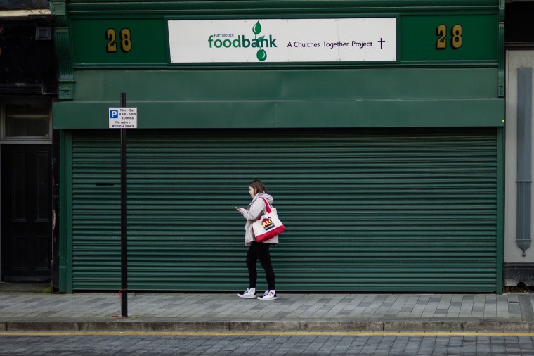 Image: A woman walks past a food bank in Hartlepool.