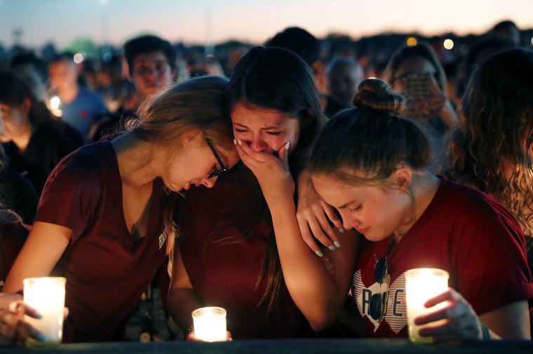 Image: Students console each other during a candlelight vigil for the victims of the shooting at Marjory Stoneman Douglas High School
