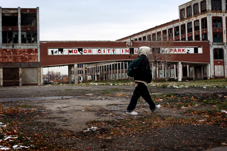 Image: A man walks past the former Packard Motor Car Company building in Detroit in 2008.