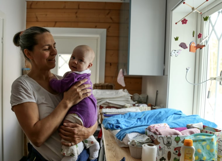 Image: Ismahni Bjorkman, 45, who lives 38 miles north of Stockholm, mends clothing, uses reusable cloth diapers and buys toys that are either second-hand or made of sustainable materials to help protect the planet.