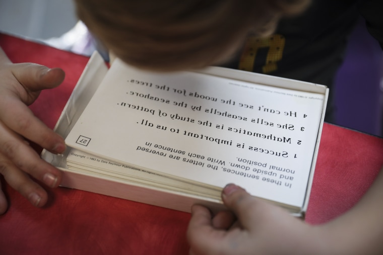 Kyle Gregory attempts to read flash cards that are backwards and upside down during a training session at LearningRx.