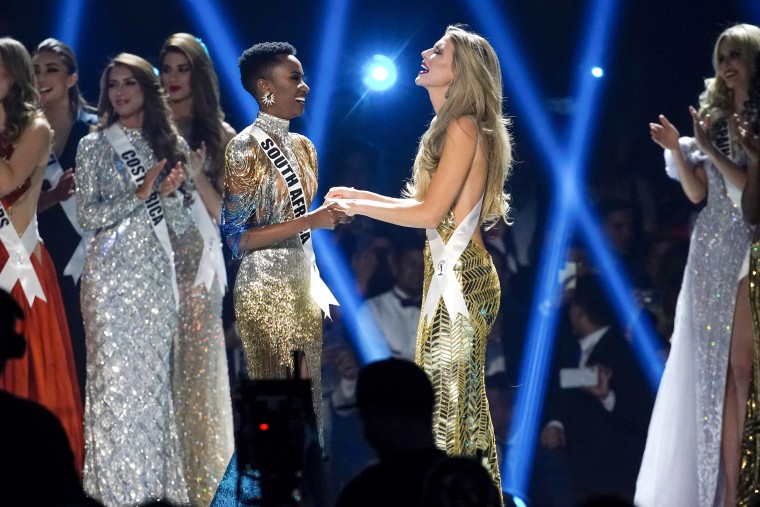 Image: The final two contestants hold hands in the Miss Universe pageant at Tyler Perry Studios in Atlanta