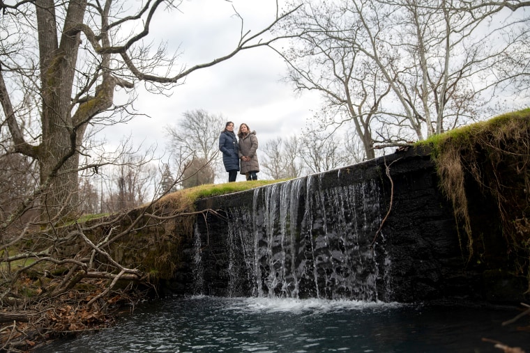 Hope Grosse and Joanne Stanton stand above a waterfall in Graeme Park, in Horsham Township, Pa.