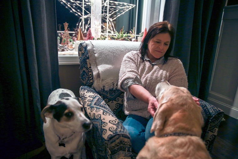 Lori Cervera sits at home with her dogs in Horsham Township, Pa.
