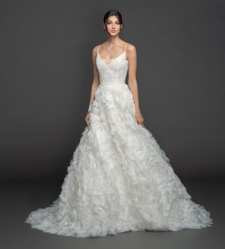 Dramatic and voluminous, this ivory organza gown features a scalloped sweetheart neckline and a lace corset bodice. 