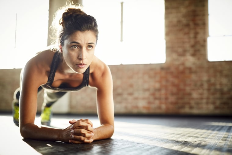 Fit young woman exercising at gym Stock Photo