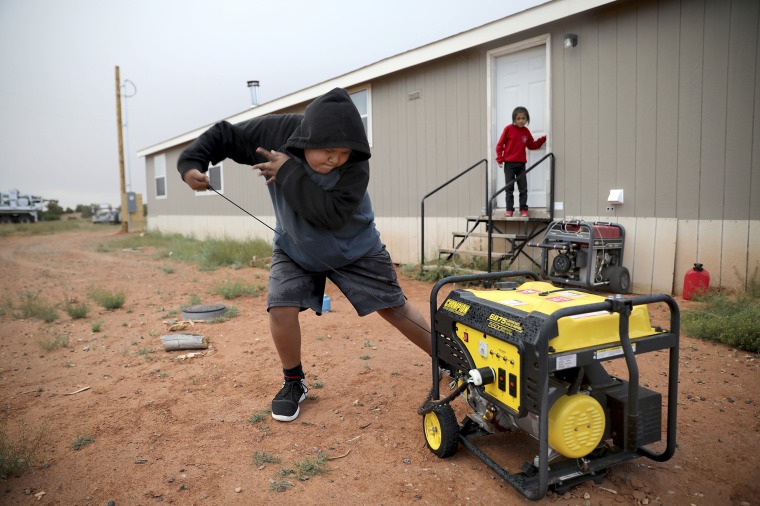 Jayden Long, 13, starts the generator behind his home on the Navajo Reservation in Arizona so that he can charge his cell phone inside the family home on May 8, 2019.