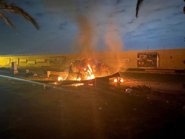 Image: Burning debris are seen on a road near Baghdad International Airport